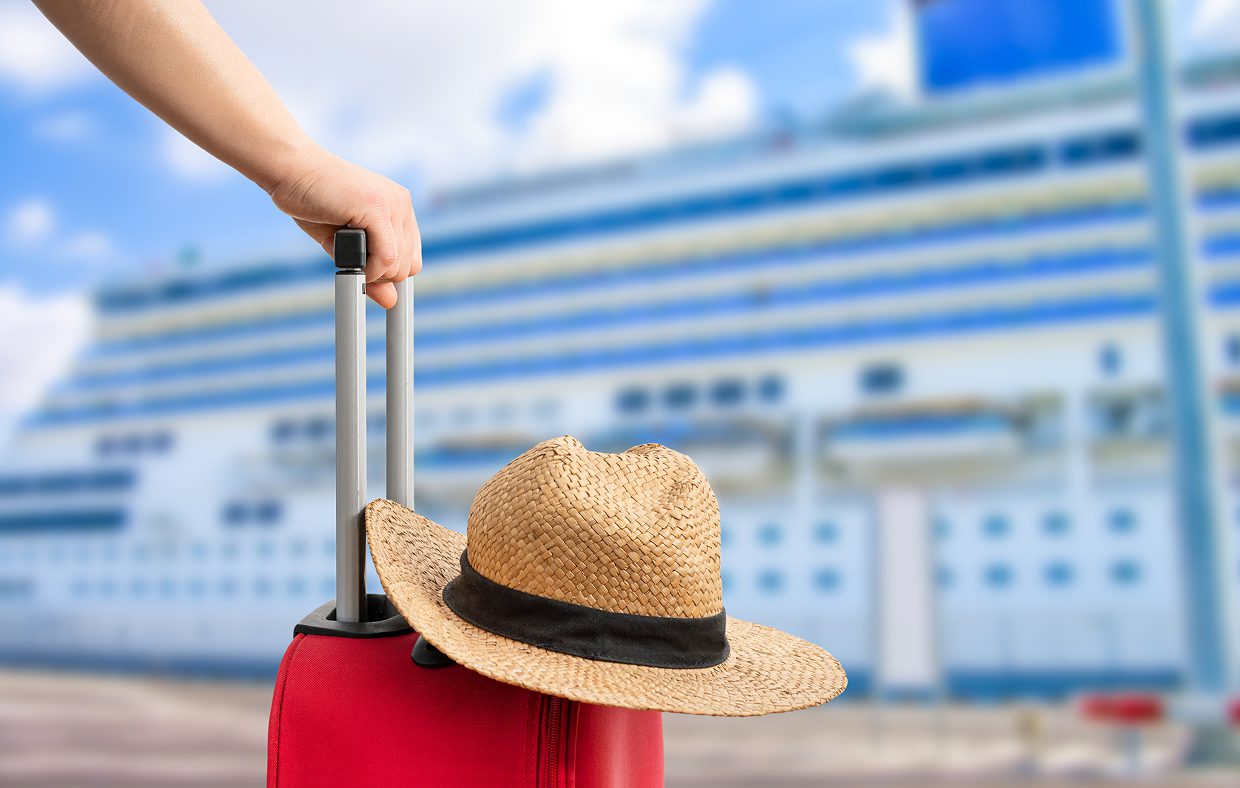 Straw hat on luggage by cruise liner