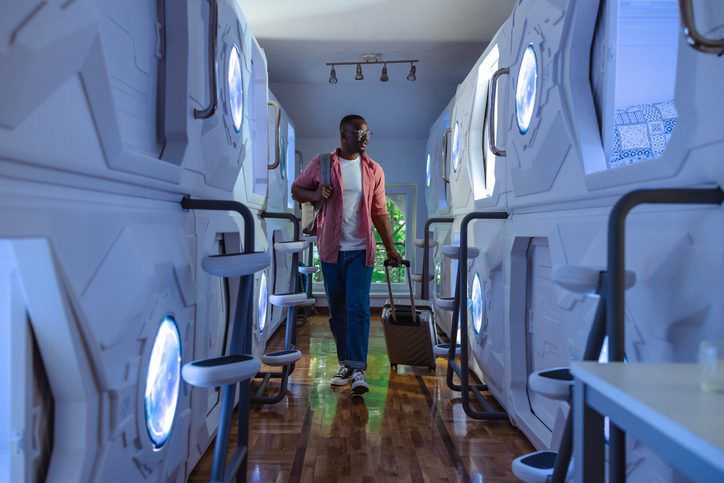 Man walking through futuristic capsule hotel